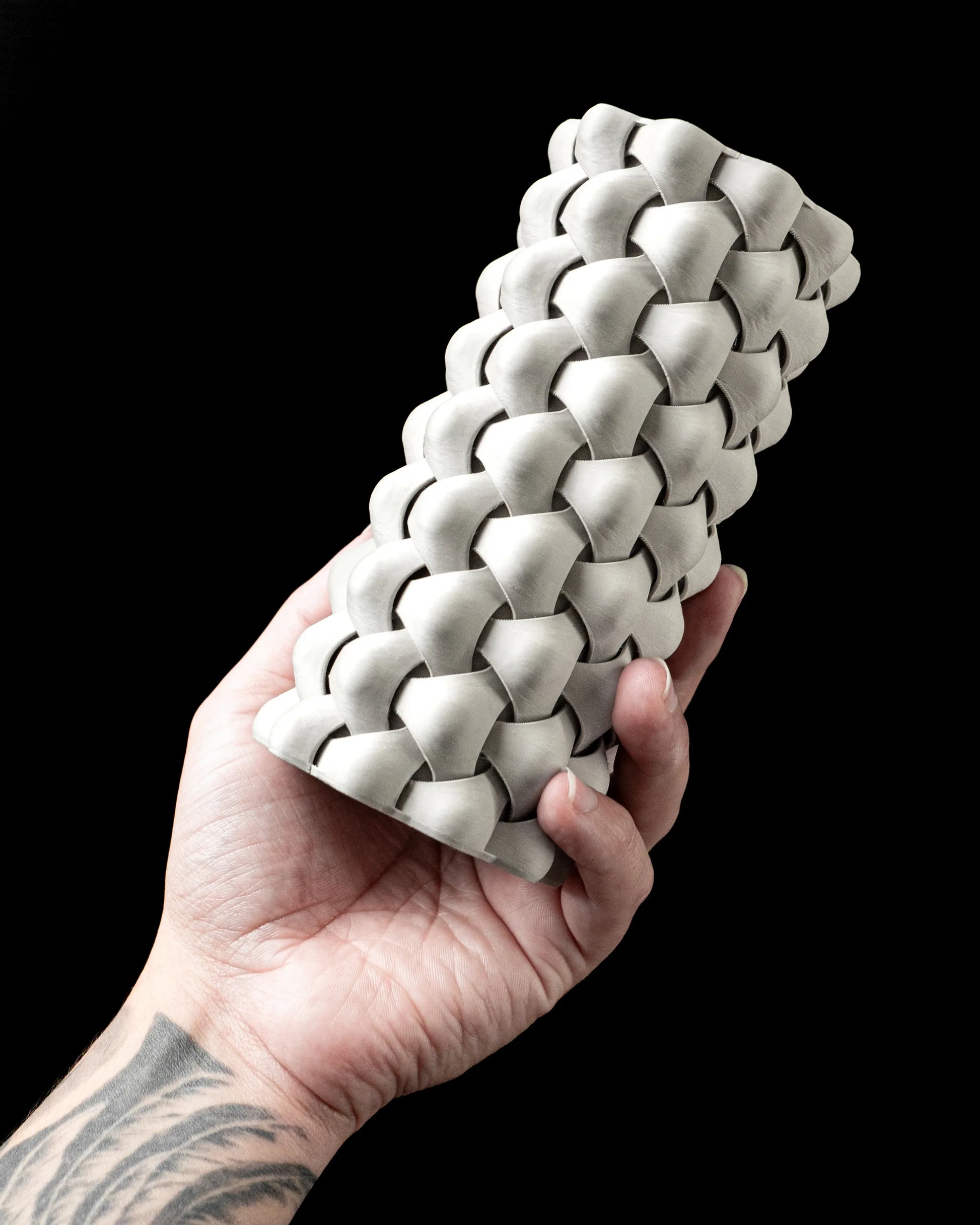 Vase étanche blanc cassé avec texture tressée en relief, forme cylindrique allongée, design moderne.