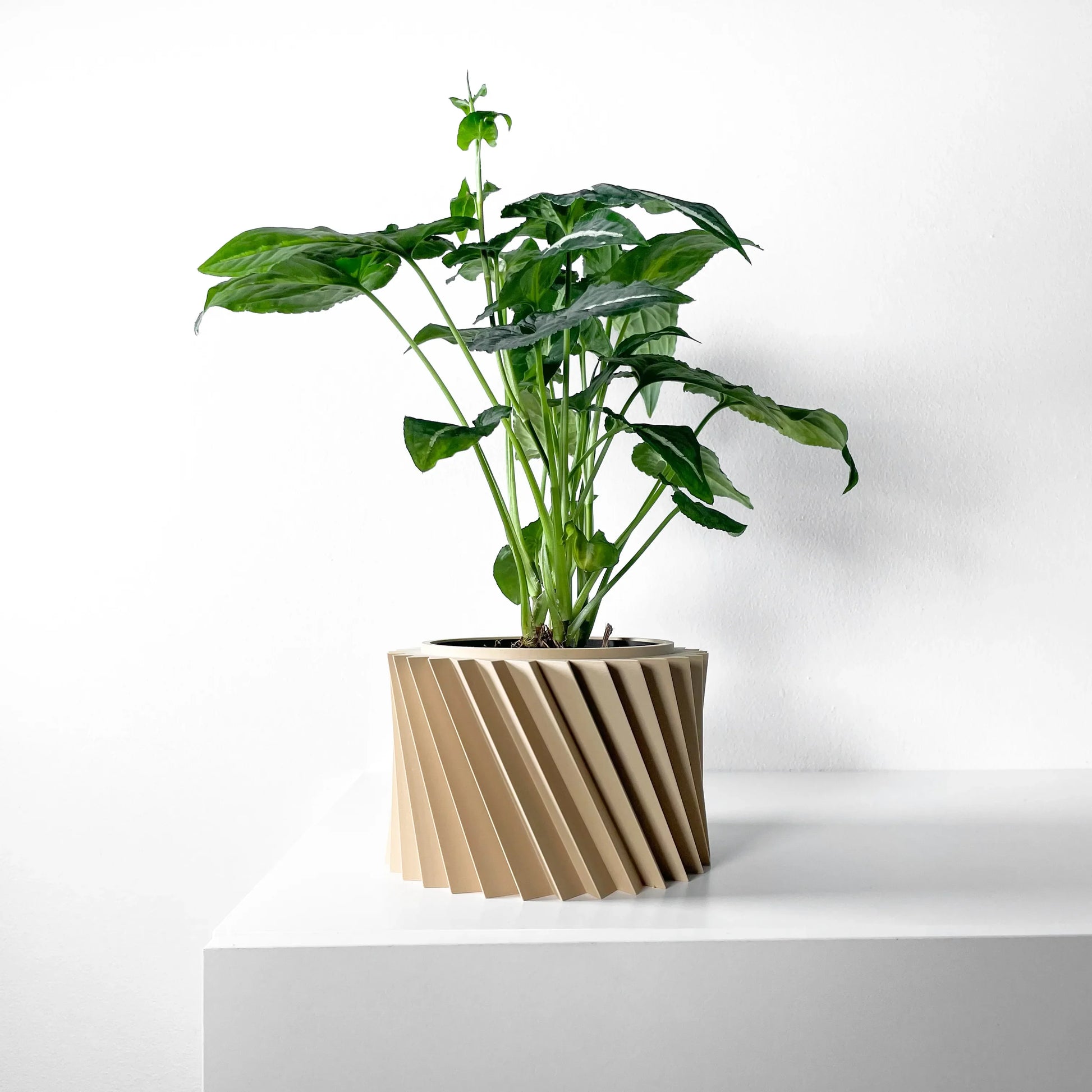 Pot décoratif Wiron beige en matériau durable avec design contemporain à rainures diagonales, plante verte luxuriante.