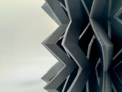 Lampe de table design contemporain noir mat avec abat-jour translucide en plastique durable à motifs géométriques zigzag.